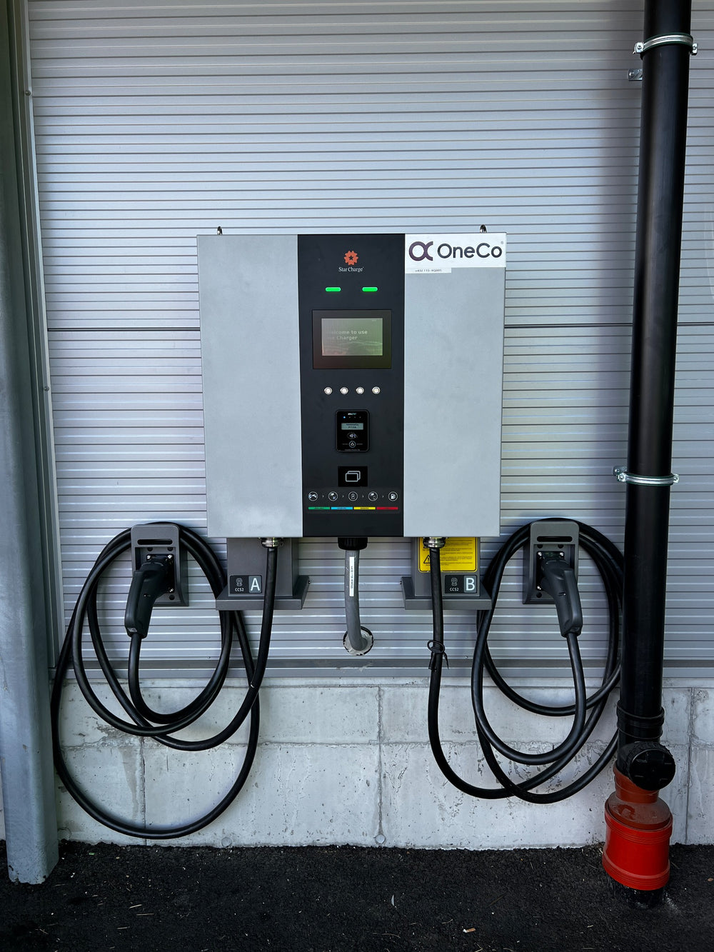 A wall-mounted charging installation with dedicated cable storage.