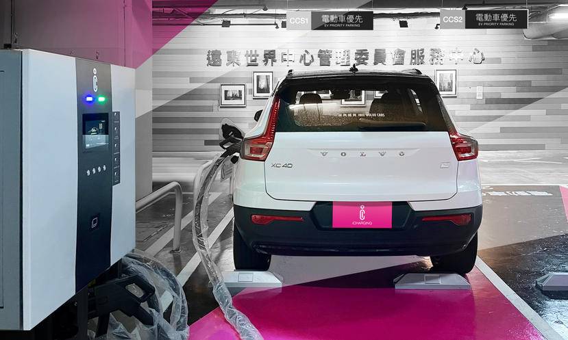 A passenger vehicle displayed beside an EV charging unit.