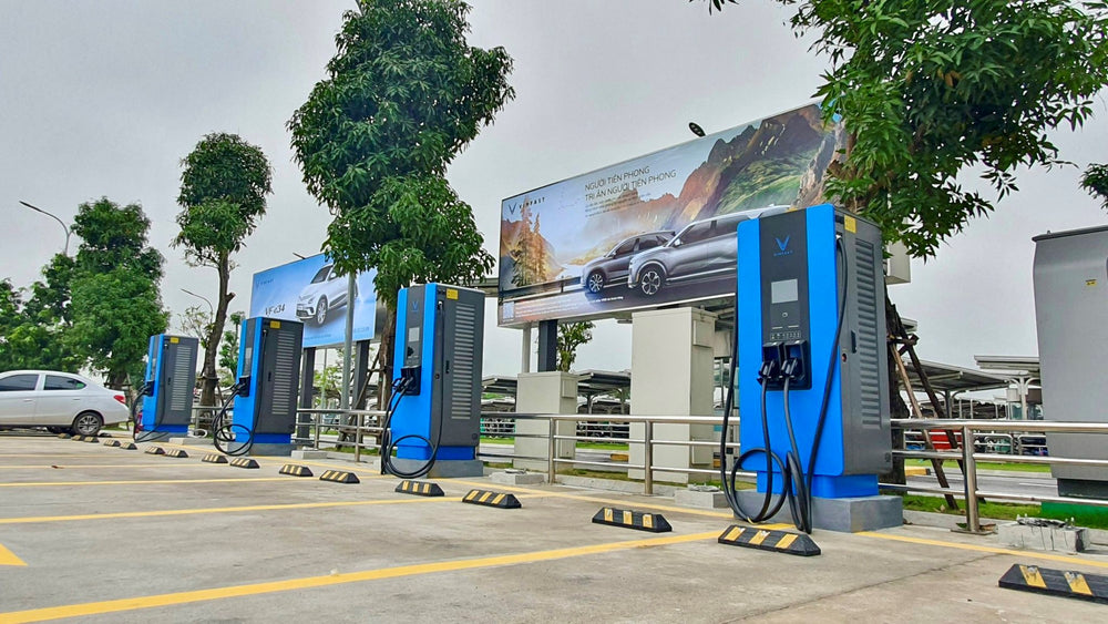 Multiple blue EV charging stations at an outdoor site in Vietnam